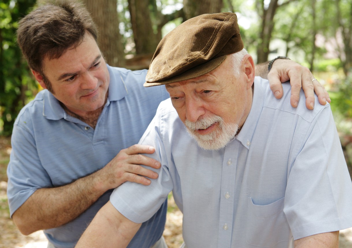 Senior man in failing health and his worried middle-aged son.  Focus on Senior man.  